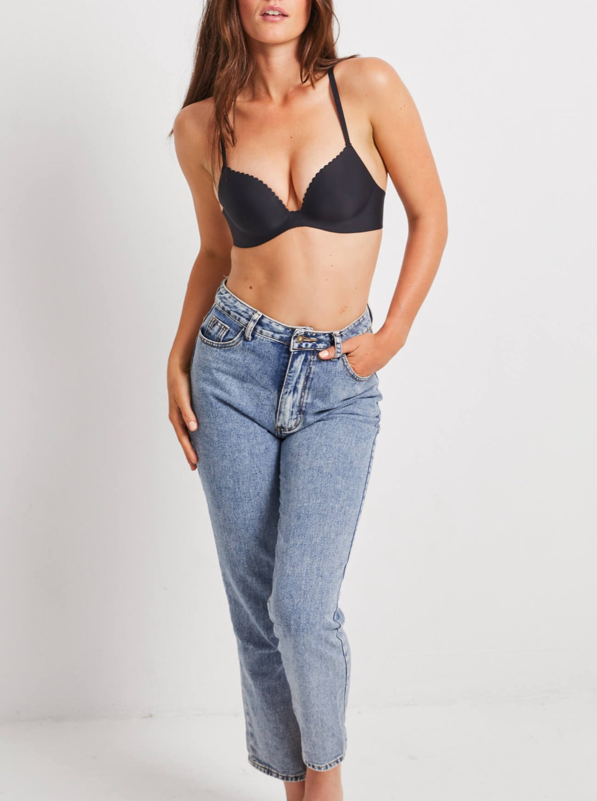Woman standing wearing Kayser Very Smooth One Piece Bra in Black with jeans
