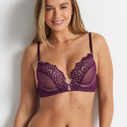 Woman wearing the burgundy After Dark No Rules Push Up Bra by Kayser Lingerie and matching briefs, standing against a light blue background.