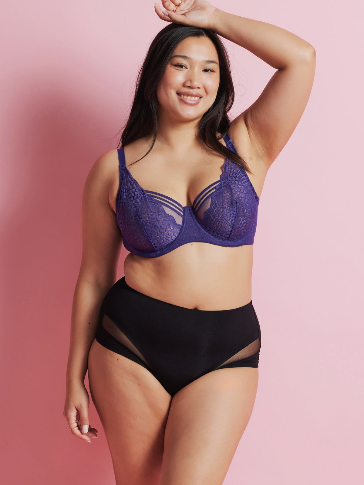 Woman wearing the mulberry Hold Up Epic Lace Underwire Bra and matching briefs against a pink background.